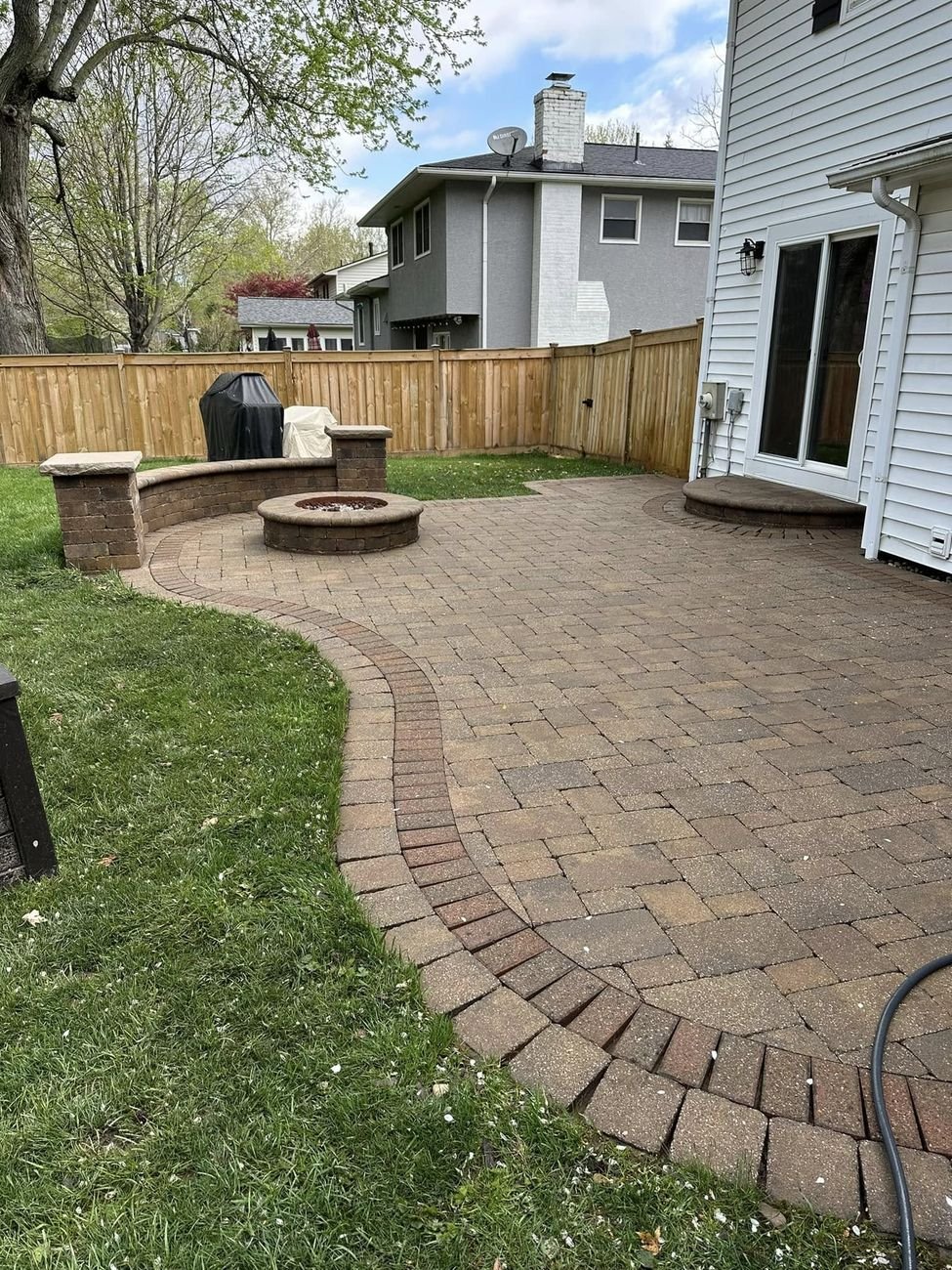 The same patio after washing and drying, pavers back to warm tan with the seat wall and fire pit sharp again
