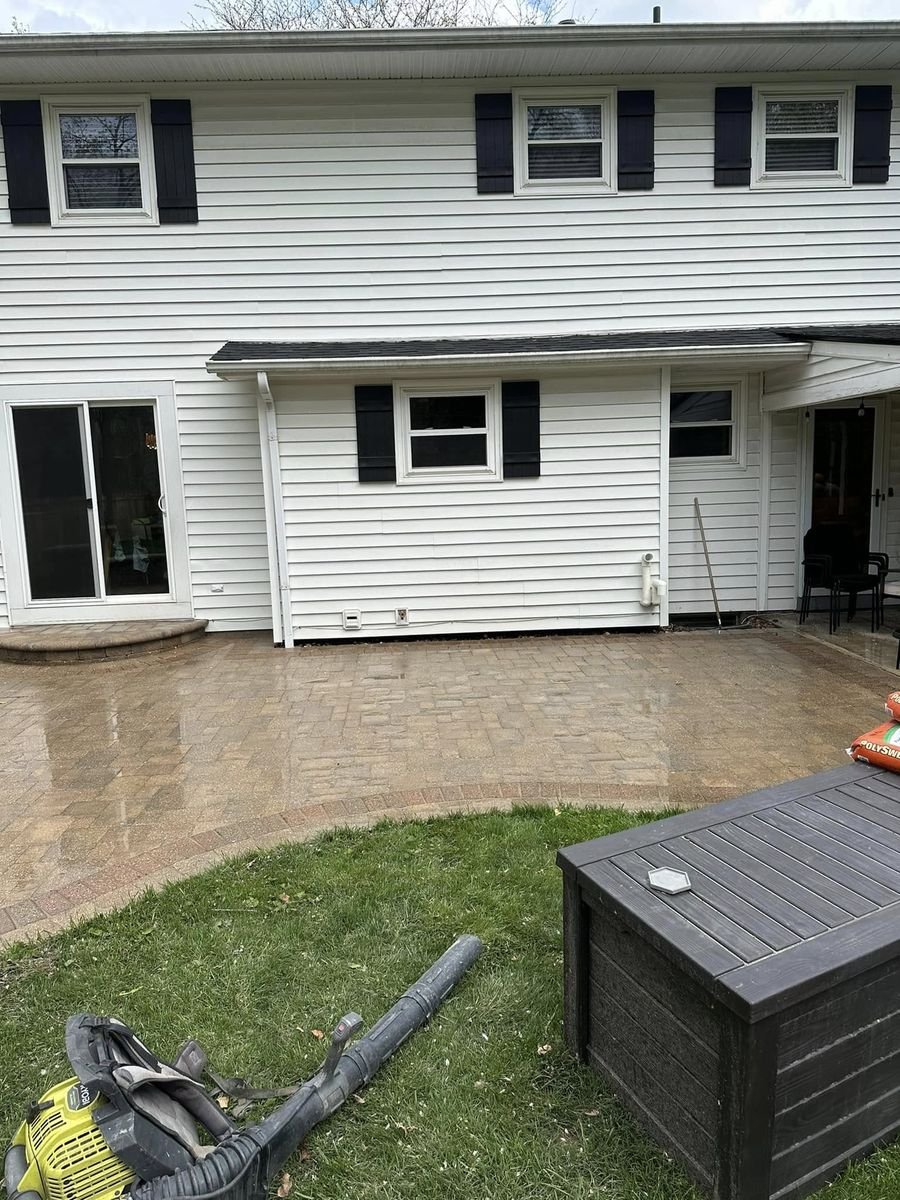 Washed pavers at the back of the white house, warm toned and wet with the joints cleared out
